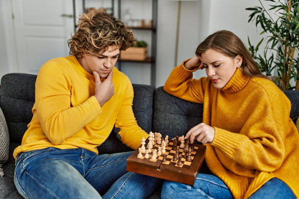 Jovem casal caucasiano se concentrar jogando xadrez em casa - Fotografia, imagem
