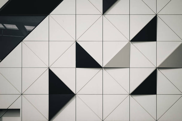 A closeup shot of black and white triangular tiles on a wall - Foto, afbeelding