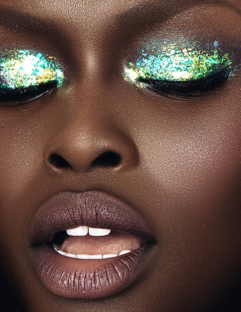 A vertical close-up shot of an Australian black model's face in gorgeous make-up. - Foto, Bild