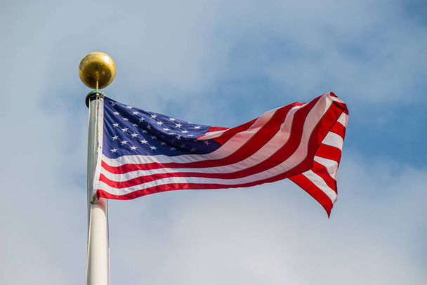 An American flag on the flagpole waving in the wind - Φωτογραφία, εικόνα