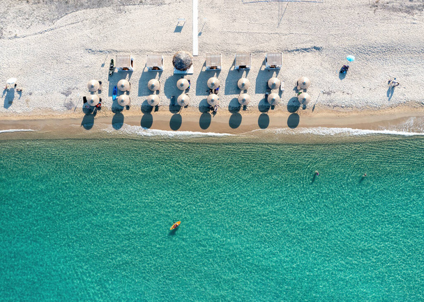 Greece, sandy beach, aerial drone view. People swim and relax at Chalkidiki peninsula. Sunny summer day, travel destination - Photo, Image