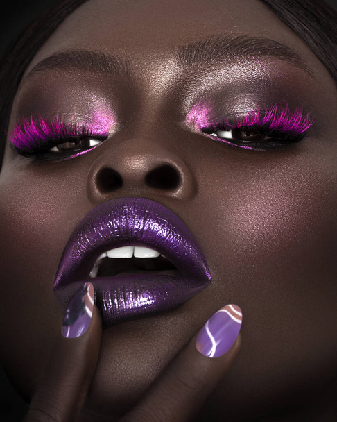A vertical close-up shot of an Australian black model's face in gorgeous make-up. - Photo, image