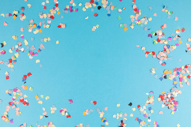 A blue background with colorful confetti and copy space - Photo, image