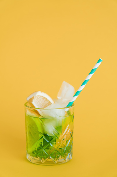 sliced citrus fruit in glass with mojito drink and straw on yellow  - Zdjęcie, obraz