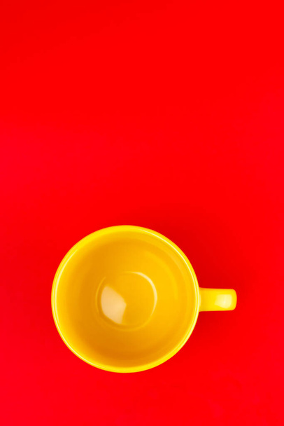A top view of a yellow cup on a red background - Foto, afbeelding