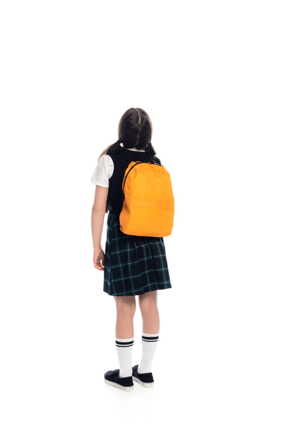 Back view of preteen schoolgirl with backpack standing on white background - Zdjęcie, obraz