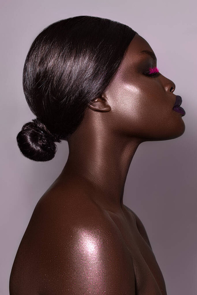 A vertical close-up shot of an Australian black model's face in gorgeous make-up. - Foto, afbeelding