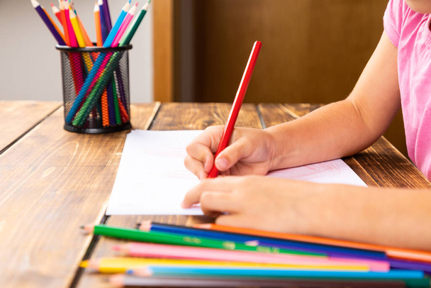 A girl drawing on a wooden desk - Photo, Image