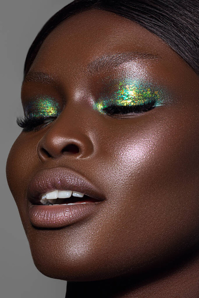 A vertical close-up shot of an Australian black model's face in gorgeous make-up. - Foto, imagen