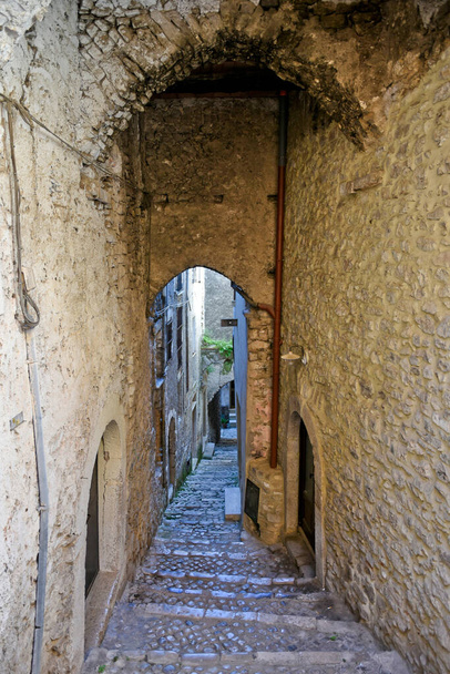 A street between old medieval stone buildings of a historic town in Lazio region, Italy - 写真・画像