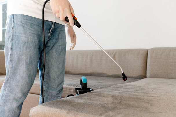 Nettoyeurs à sec employés enlever la saleté des meubles dans l'appartement
 - Photo, image