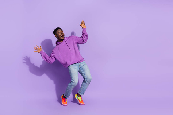 Full size portrait of excited crazy person raise hands look empty space isolated on violet color background. - 写真・画像