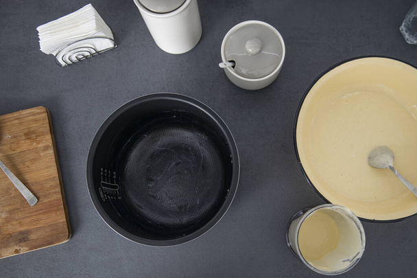 Dough in a bowl is kneaded on a kitchen surface. Top view baking dish, flat lay. - Photo, image