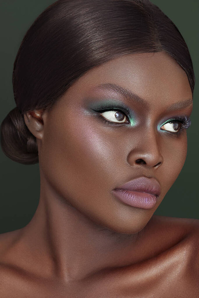 A vertical close-up shot of an Australian black model's face in gorgeous make-up. - Foto, Imagen