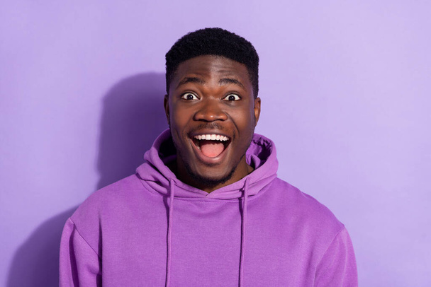 Portrait of attractive amazed cheerful guy wearing sweatshirt isolated over bright violet lilac color background. - Photo, Image