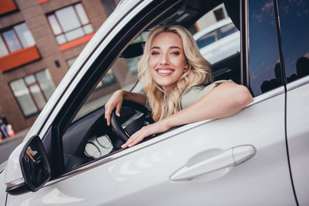 Photo of confident cheerful person sitting car front seat look through door window have good mood. - Фото, зображення