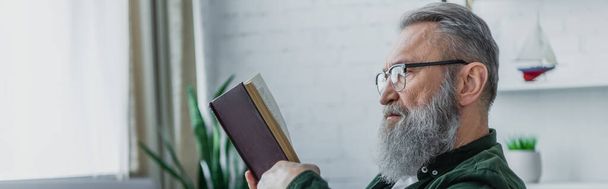 bearded senior man in eyeglasses reading book at home, banner - Foto, Imagen