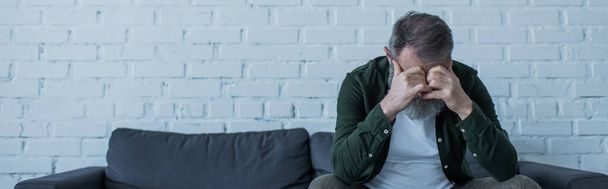 masentunut vanhempi mies harmaat hiukset istuu sohvalla olohuoneessa, banneri - Valokuva, kuva