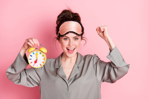 Portrait of astonished lady hand hold clock fist up celebrate open mouth isolated on pink color background. - Fotoğraf, Görsel