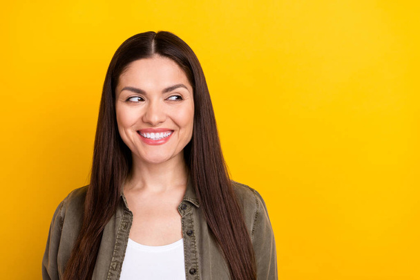 Photo of cunning pretty young woman wear khaki outfit looking empty space smiling isolated yellow color background. - Foto, Imagem