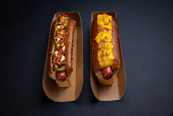 Hot dogs in paper plates with sausages and sauce - Foto, Bild
