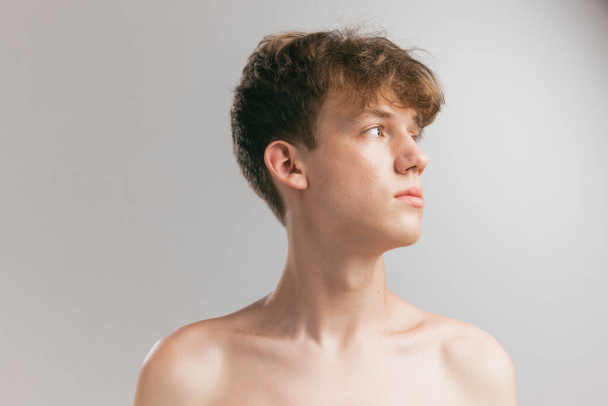 Neck and shoulders. Closeup young man, teen isolated on grey studio background. Concept of teenage skin care, health, cosmetics for problem skin, youth. Art, fashion, healthy lifestyle and ad - Φωτογραφία, εικόνα