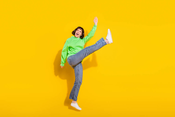 Full length body size view of nice crazy cheerful girl jumping fooling isolated over bright yellow color background. - Foto, afbeelding
