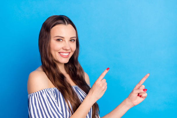 Photo of adorable sweet young lady wear off-shoulders clothes pointing fingers empty space smiling isolated blue color background. - Foto, Imagen