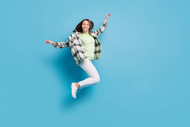 Full size profile side photo of young cheerful girl happy positive smile carefree jump fly isolated over blue color background. - Fotó, kép