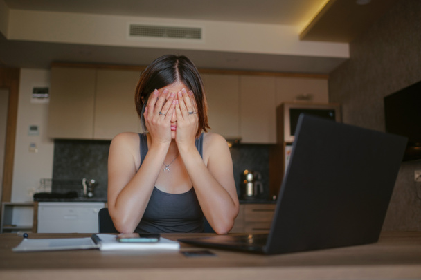 Gefrustreerde trieste vrouw voelt zich moe, bezorgd over probleem zitten aan de laptop, depressief meisje bezorgd over het lezen van slecht nieuws online, schuldmelding e-mail of negatief bericht - Foto, afbeelding