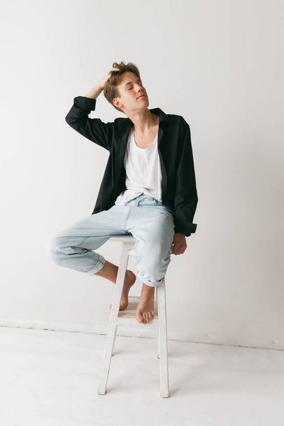Dreams. Portrait of young man, teen, student posing isolated over white studio background. Fashion male model in casual style clothes. Concept of art, beauty, fashion, youth culture, sales and ads - 写真・画像