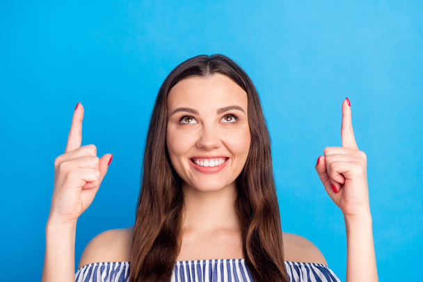 Photo portrait woman pointing finger up copyspace smiling advising happy isolated vivid blue color background. - Фото, изображение