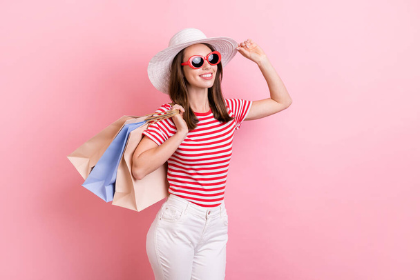 Profile side photo of young girl wear hat sunglass hold shopping bag shopaholic isolated over pastel color background. - Φωτογραφία, εικόνα