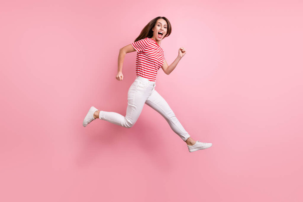 Full length profile side photo of young girl happy positive smile hurry fast sale go runner isolated over pink color background. - 写真・画像