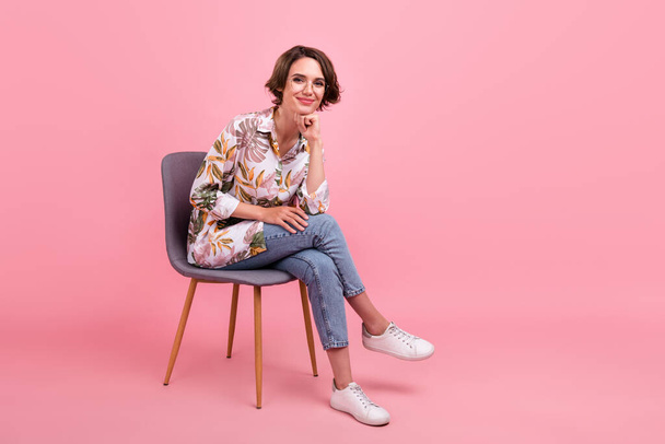 Full length body size photo woman sitting on chair in casual clothes isolated pastel pink color background. - Fotografie, Obrázek