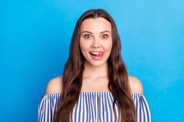 Photo of sweet funny young lady wear off-shoulders clothes tongue licking lips smiling isolated blue color background. - Photo, image
