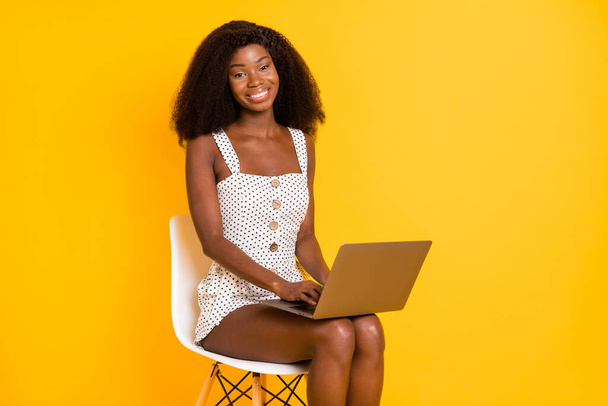 Photo of nice optimistic cute brunette lady sit write laptop wear white dress isolated on vivid yellow background. - Фото, изображение