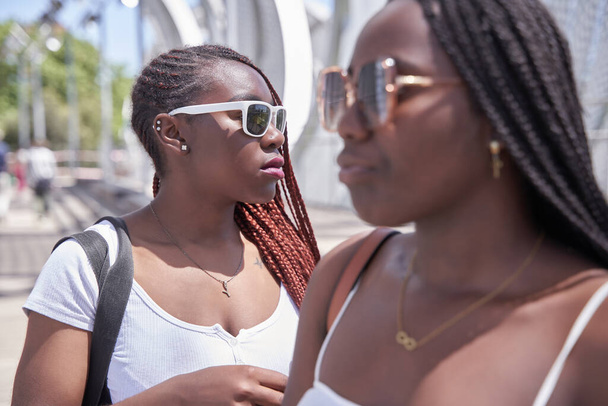 Селективний фокус на двох афро-американських жінок з колючками і сонцезахисними окулярами на відкритому повітрі - Фото, зображення