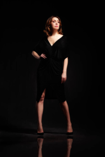 High fashion portrait of elegant woman in long black dress. Over Black background - Fotó, kép