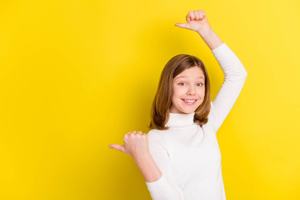 Photo of attractive young happy girl smile point finger empty space promoter isolated on yellow color background. - Zdjęcie, obraz