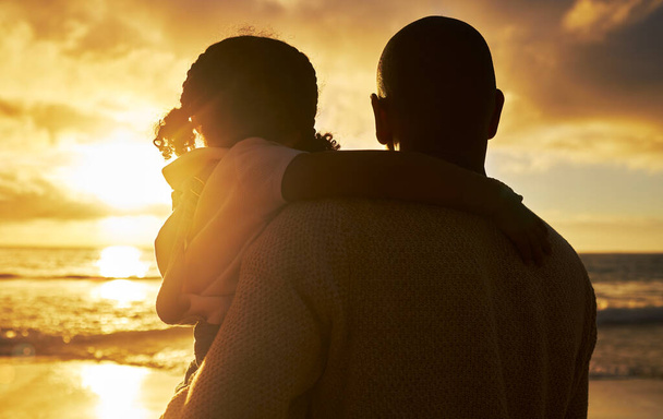 Silhouette of a loving father and daughter watching the view at sunset. Family looking at the beautiful golden sky while on holiday. Little girl and dad bonding and enjoying time together on vacation. - Photo, Image