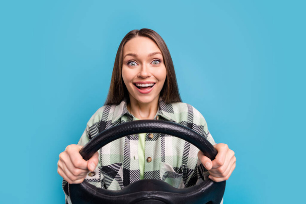 Photo of young excited girl happy positive smile driver steering-wheel travel isolated over blue color background. - Photo, image