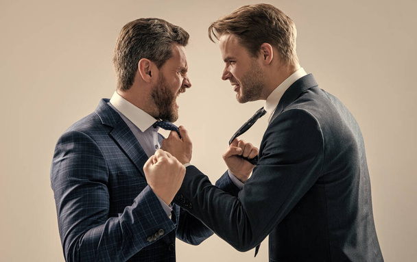two angry businessmen punching in fight and arguing having struggle for leadership on businessmeeting because of business competition, aggressive negotiations. - Fotografie, Obrázek