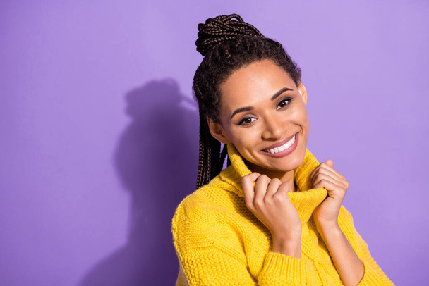 Photo of optimistic brunette lady near empty space touch yellow sweater isolated on purple color background. - Foto, Imagem