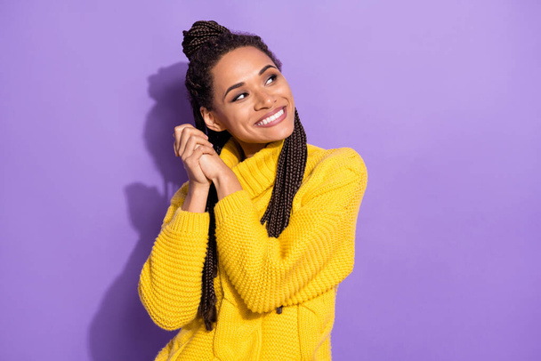 Photo of optimistic nice brunette girl hold hands look empty space wear yellow sweater isolated on purple color background. - Foto, Bild