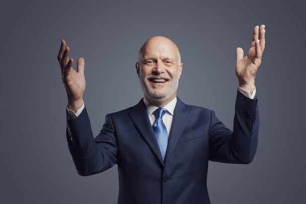Cheerful business executive celebrating with hands up, successful business concept - Фото, зображення