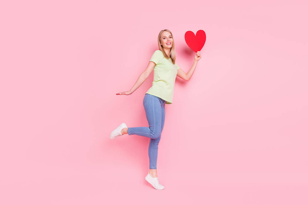 Full length body size view of attractive cheerful girl jumping posing holding heart health care isolated over pink pastel color background. - Foto, immagini