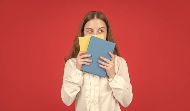 kid in white shirt ready to study do homework behind book on red background, knowledge. - Photo, Image