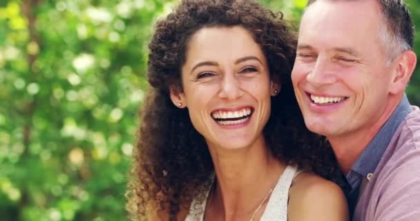 Portrét veselého dospělého páru, smějícího se s širokými úsměvy a spojujícího se v zahradě nebo parku venku s kopírovacím prostorem. Tváře šťastného muže a ženy v láskyplný vztah těší bezstarostný den. - Záběry, video