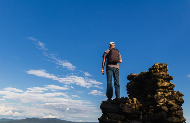 Молодий чоловік з рюкзаком стоїть на скелі складеному з каменю. Чеський літній пейзаж, природний заповідник - Фото, зображення